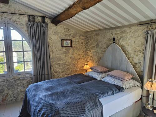 une chambre avec un lit avec des draps bleus et une fenêtre dans l'établissement Le Mas Saint Pierre, à Roquefort-les-Pins