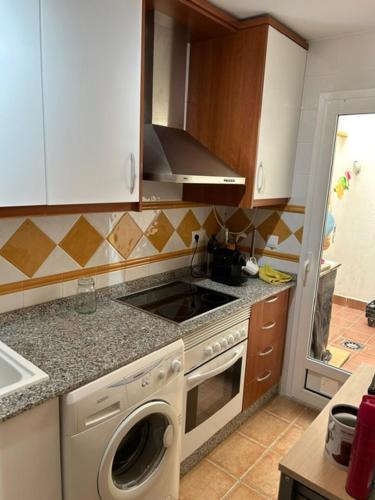 a kitchen with a stove and a washing machine at AL ANDALUS-THALASSA Premium in Vera