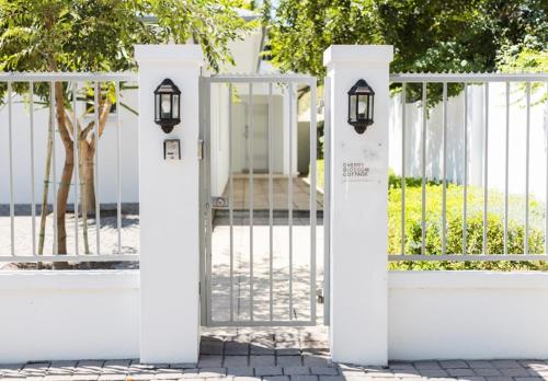 a white fence with a gate with lights on it at Cherry Blossom in Ceres