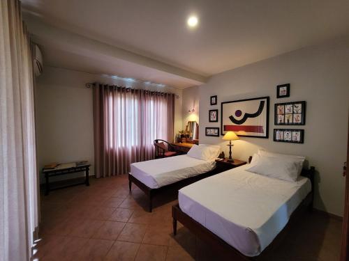 a hotel room with two beds and a window at Serene Reach Villa in Kandy