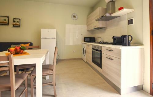 eine Küche mit einem Tisch und einem weißen Kühlschrank in der Unterkunft Lovely Apartment In Trappeto With Wifi in Trappeto