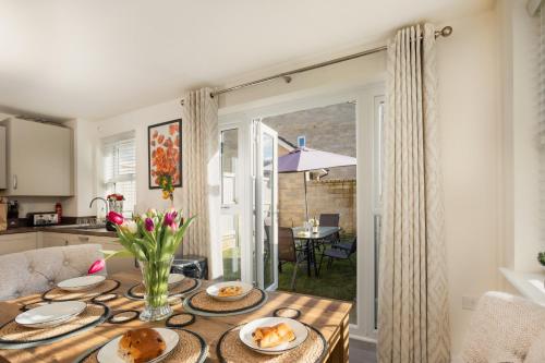 a kitchen and dining room with a table with food on it at Peak District New Modern Cottage with Mountain Views in Buxton