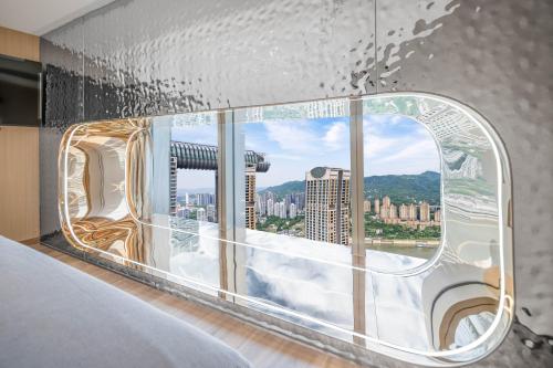 a room with a window with a view of a city at 重庆Indition英迪逊高空酒店 解放碑来福士店 in Chongqing
