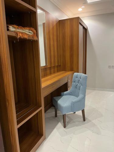 a room with a desk and a blue chair at أجنحة وجهة الوصول in Bisha