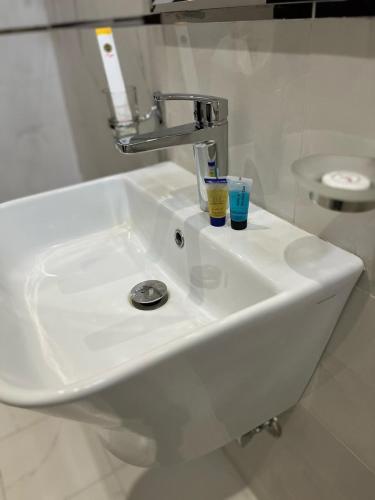 a white bathroom sink with two cups on it at أجنحة وجهة الوصول in Bisha