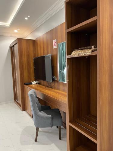a desk with a computer and a chair in a room at أجنحة وجهة الوصول in Bisha