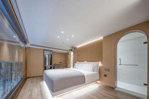 a bedroom with a white bed and a balcony at 重庆Indition英迪逊高空酒店 解放碑来福士店 in Chongqing