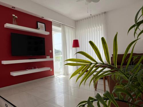 a living room with a tv and a plant at Villa Evita - Sea View Apartment by Kostas in Afitos