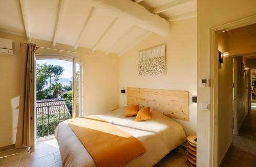 une chambre avec un lit et une grande fenêtre dans l'établissement Villa des Cigales vue mer avec piscine/proche plage, à Grimaud