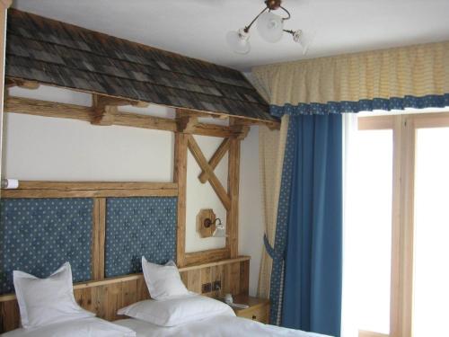 a bedroom with two beds and a large window at Paradise Lodge in Livigno
