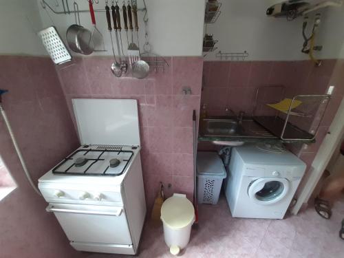 a small kitchen with a stove and a sink at Retro Kuckó in Balatonfenyves