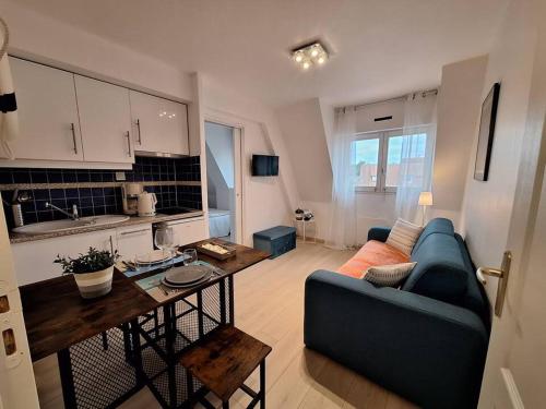 a living room with a couch and a table at Super Deauville appartement 2 pièces cosy proche plage plein sud in Villers-sur-Mer