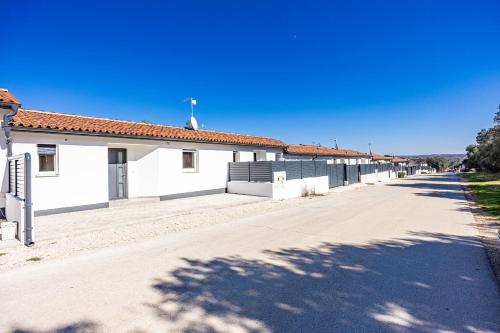 an empty street in front of a white building at Barbariga Summer Beach Paradise 2 in Peroj