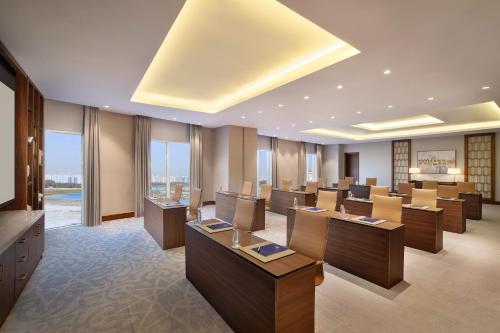 a conference room with desks and chairs and windows at Hilton Al Khobar King Fahd Causeway in Al Khobar