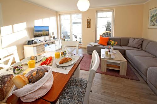 a living room with a table with food on it at Exkl App Seestern, W-LAN, 250 m zum Strand in Börgerende-Rethwisch