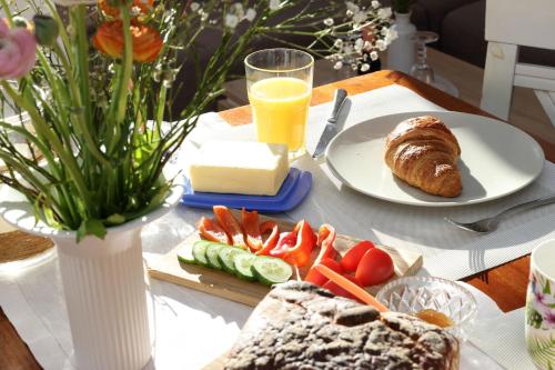 a table with a plate of bread and a plate of food at Exkl App Seestern, W-LAN, 250 m zum Strand in Börgerende-Rethwisch