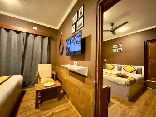 a hotel room with two beds and a tv at Hotel Jafson Accommodates in Srinagar
