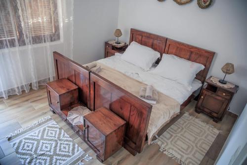 a bedroom with a large wooden bed with white pillows at Kuća za odmor Grđan in Slatinski Drenovac