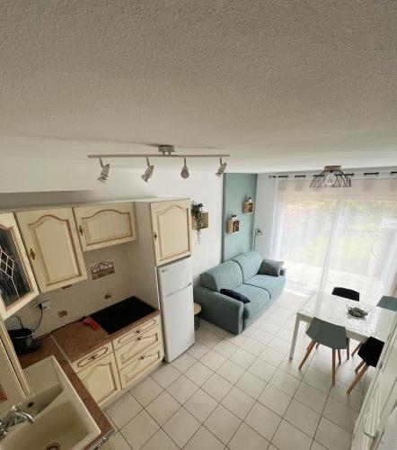a kitchen and living room with a couch and a table at Maison des Pins, Baie de Somme, Cayeux-sur-Mer in Cayeux-sur-Mer