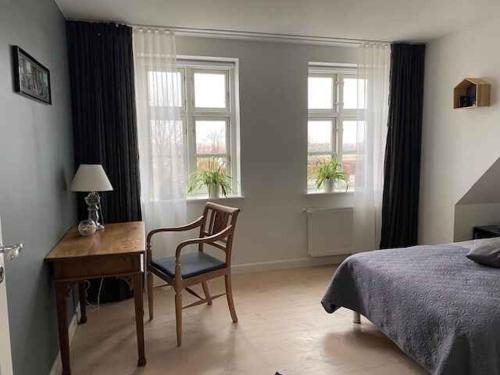 a bedroom with a desk and a bed and windows at Luxury Country House In Nature With Wellness in Haderslev
