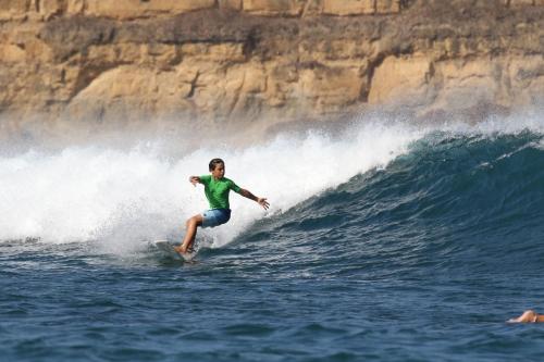 a man riding a wave on a surfboard in the ocean at ekasboardriders surf&stay in Ekas