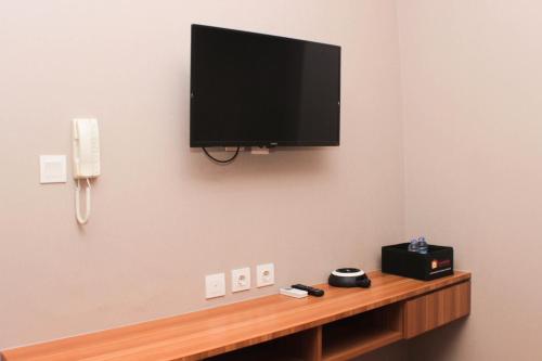 a flat screen tv hanging on a wall at Fancy and Comfy 2BR Apartment at Springlake Summarecon By Travelio in Bekasi