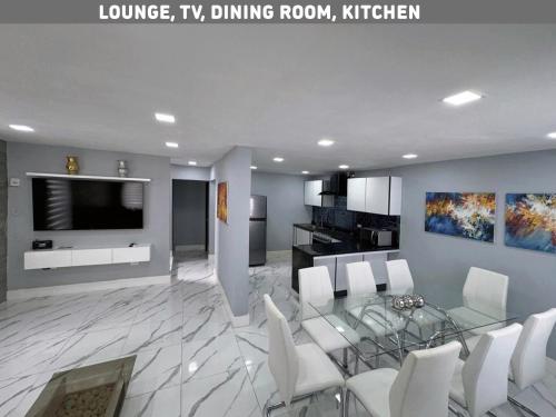 a living room with a glass table and white chairs at Brisas Bahía Azul Villa para 12 personas en Cancún in Cancún