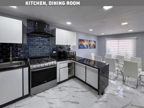 a kitchen with white cabinets and a stove top oven at Brisas Bahía Azul Villa para 12 personas en Cancún in Cancún