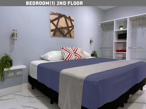 a bedroom with a large bed with a blue blanket at Brisas Bahía Azul Villa para 12 personas en Cancún in Cancún