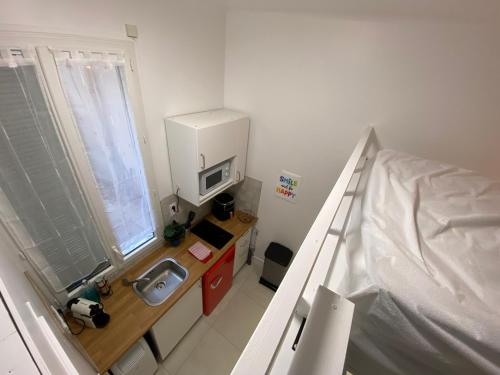 une petite salle de bain avec un lavabo et un lit dans l'établissement Studio Garibaldi, à Nice