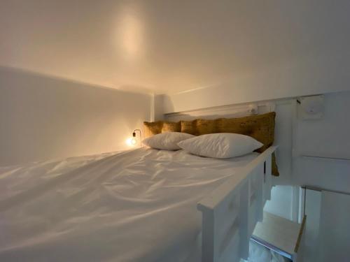 un lit blanc avec deux oreillers dessus dans l'établissement Studio Garibaldi, à Nice