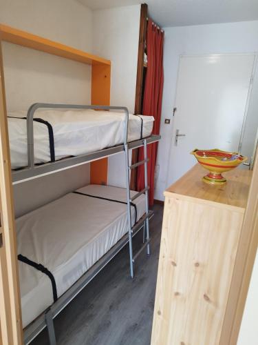 Cette chambre dispose de lits superposés avec 2 lits superposés et une table. dans l'établissement Studio - Les Hauts d'Azur, à Saint Pierre La Mer
