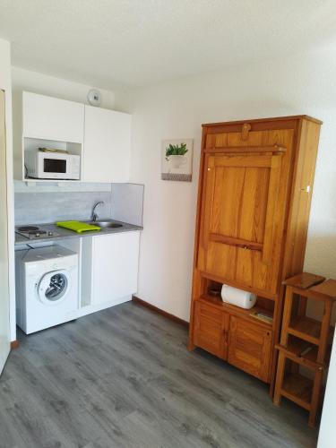 une petite cuisine avec un évier et une cuisinière dans l'établissement Studio - Les Hauts d'Azur, à Saint Pierre La Mer