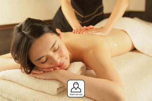 a woman getting a massage in a towel at ZONK HOTEL Nakasu-Deaibashi in Fukuoka
