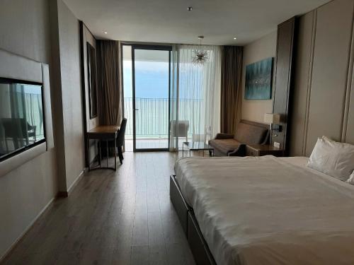 ニャチャンにあるPanorama Nha Trang Emerald Skyの大きなベッドとリビングルームがあるホテルの部屋