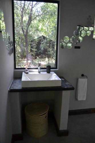 a bathroom with a sink and a window at Klein Eden Forest in Rustenburg