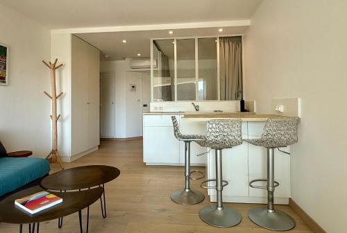une cuisine avec un comptoir et deux tabourets de bar dans l'établissement Mira Marvel - WIFI - Climatisation - 100m plage, à Biarritz