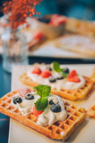 a plate of waffles with fruit on top of it at Mercure Bialystok in Białystok