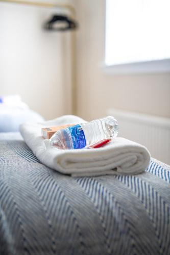 a bottle of water sitting on top of a bed at Richard Gardens in Bathgate