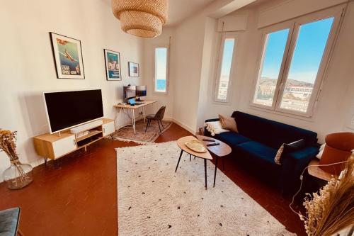 un salon avec un canapé bleu et une télévision dans l'établissement Charming Apartment at 10mn du Vieux Port, à Marseille