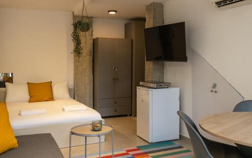 a small living room with a bed and a table at Chic Central TLV Studio in Tel Aviv
