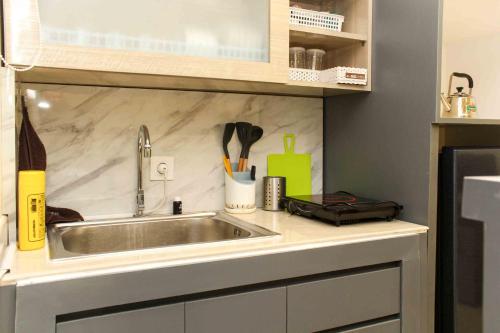 芝卡朗Comfortable and Spacious 2BR at Meikarta Apartment By Travelio的厨房柜台配有不锈钢水槽