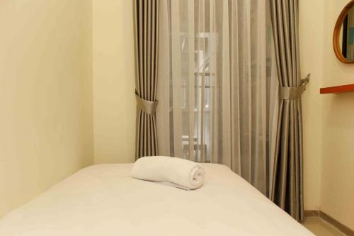 芝卡朗Comfortable and Spacious 2BR at Meikarta Apartment By Travelio的窗边床边的白色毛巾