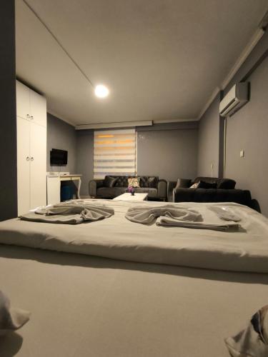a large bed in a room with a couch at Akman City Hotel in Kusadası