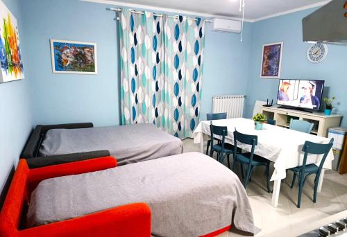 a bedroom with two beds and a table and a dining room at Casa Maurella - Sea View Apartment Ladispoli in Ladispoli