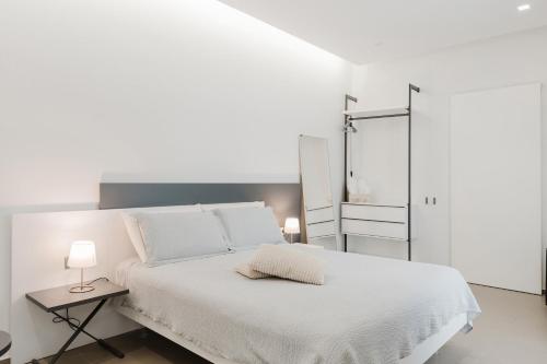 a white bedroom with a white bed and a mirror at Casa Umeli with Jacuzzi and Sauna in Marsala