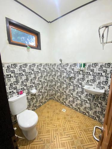 a bathroom with a toilet and a sink at Sri Sedana Guest House in Sidemen