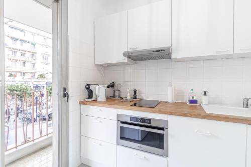 une cuisine blanche avec des armoires blanches et une fenêtre dans l'établissement Big Studio, Biovs , Central Menton, Casino, à Menton