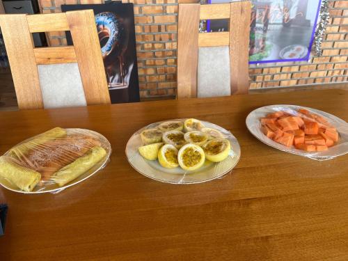 a table with two plates of fruit and a loaf of bread at Linasi Resort Sri Lanka in Ahangama