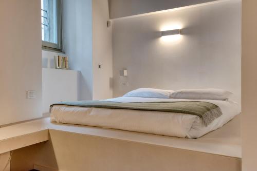 a bed sitting on a shelf in a bedroom at Domus Santa Croce in Bergamo